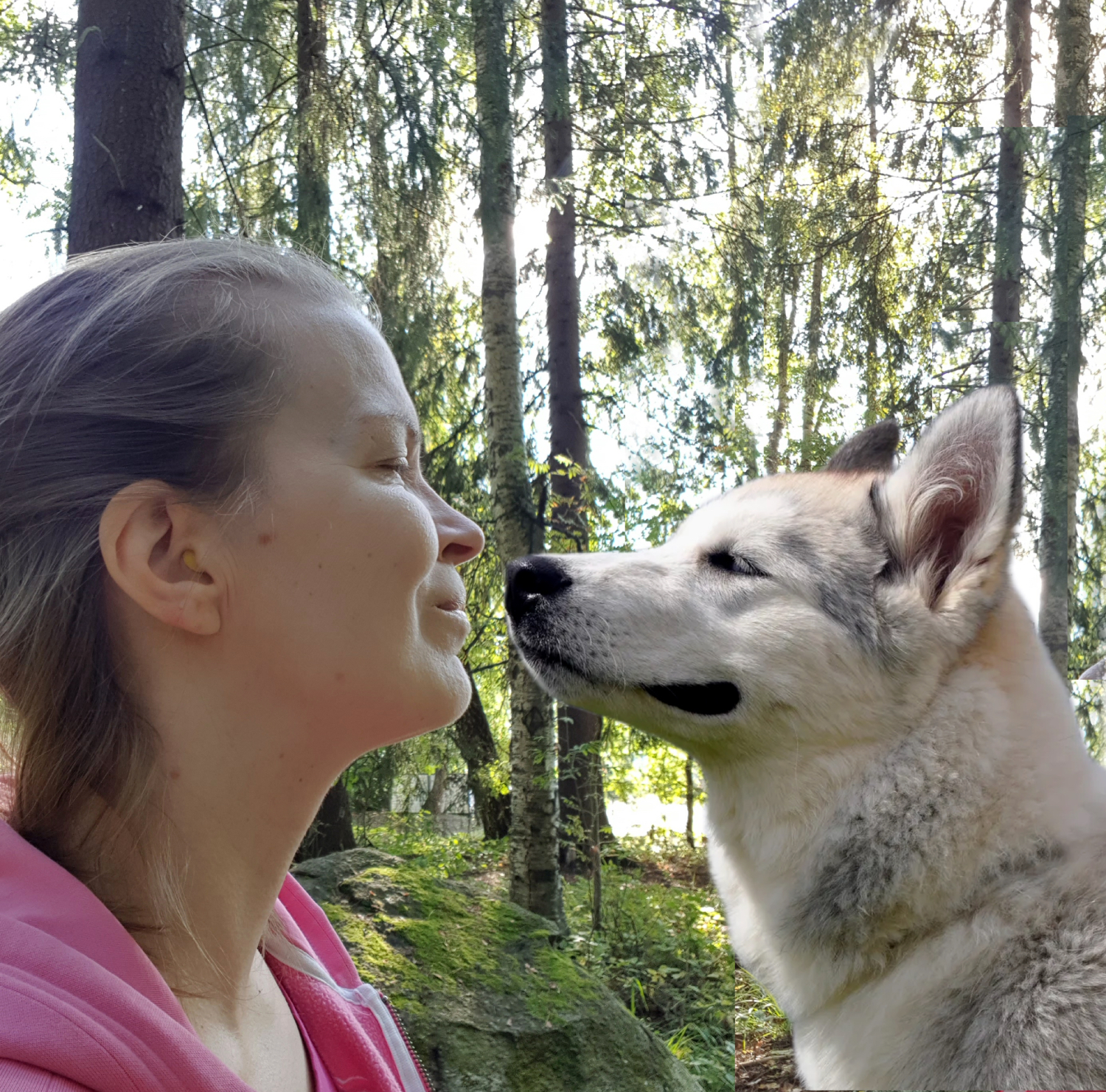 Artist Hanna Koljonen and a cute dog smiling at each other in a forest